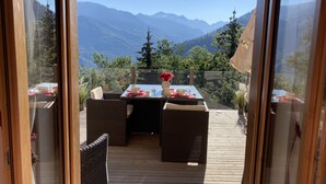 Ein Essbereich mit Tisch für zwei Personen, mit Blick auf eine Berglandschaft.