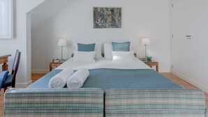 Ein Schlafzimmer mit einem großen Bett, zwei Nachttischen, einem Bild an der Wand und einem Kleiderschrank.