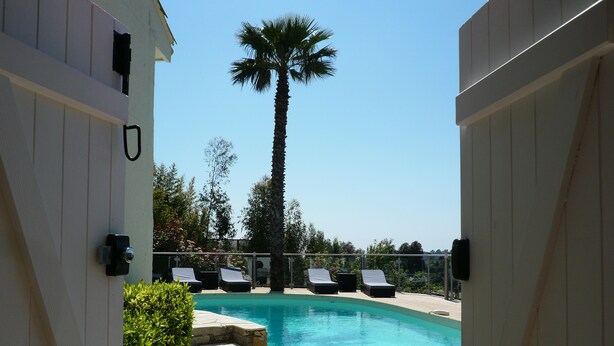 A pool area with lounge chairs, a palm tree, and a stone pathway. - 800m from the sea, pretty Provencal villa, quiet, swimming pool, garden in the Golf St. Tropez (Roquebrune-Sur-Argens)