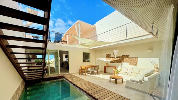 A modern outdoor living area with a pool, wooden deck, and a white sofa. - Bungalow with private pool, internet, close to the sea, courtyard, top location, parking lot (Costa Calma)