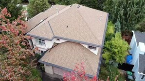 A two-story house with a sloped roof, surrounded by trees and a garden. - Family home in Surrey (Surrey)