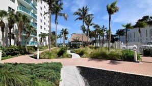 A hotel courtyard with palm trees, a pathway, and a building with balconies. - Tides-5q (Hollywood)