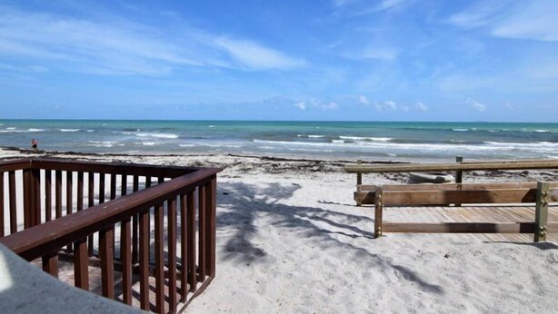 A beach with a wooden deck and a bench. - Tides-5q (Hollywood)