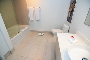 A modern bathroom with a bathtub, toilet, and sink. - Ocean & Bay View Residence 1 Bed 1 Bath @ Beachwalk Hallandale Beach (Hallandale Beach)
