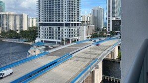 A high-rise building with a modern design, a bridge with blue railings, and a body of water in the foreground. - Ocean & Bay View Residence 1 Bed 1 Bath @ Beachwalk Hallandale Beach (Hallandale Beach)