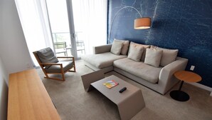 A modern living room with a sofa, a coffee table, a chair, and a small table. - Ocean & Bay View Residence 1 Bed 1 Bath @ Beachwalk Hallandale Beach (Hallandale Beach)