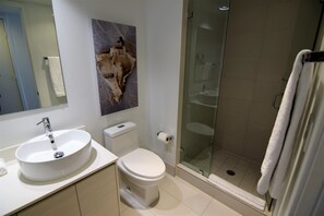 A modern bathroom with a white sink, toilet, and glass-enclosed shower. - Spectacular Ocean & Bay View Residence 1 Bed 1 Bath @ Beachwalk Resort (Hallandale Beach)