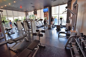A gym with various exercise equipment, large windows, and a view of the outdoors. - Spectacular Ocean & Bay View Residence 1 Bed 1 Bath @ Beachwalk Resort (Hallandale Beach)