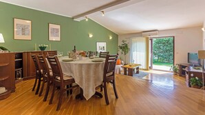 Un espace repas avec une table ronde, des chaises et un mur vert.
