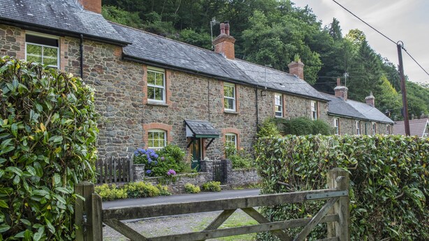 A stone house with a wooden gate, surrounded by greenery. - Robins Brook, Porlock (Porlock)