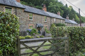A stone house with a wooden gate, surrounded by greenery. - Robins Brook, Porlock (Porlock)