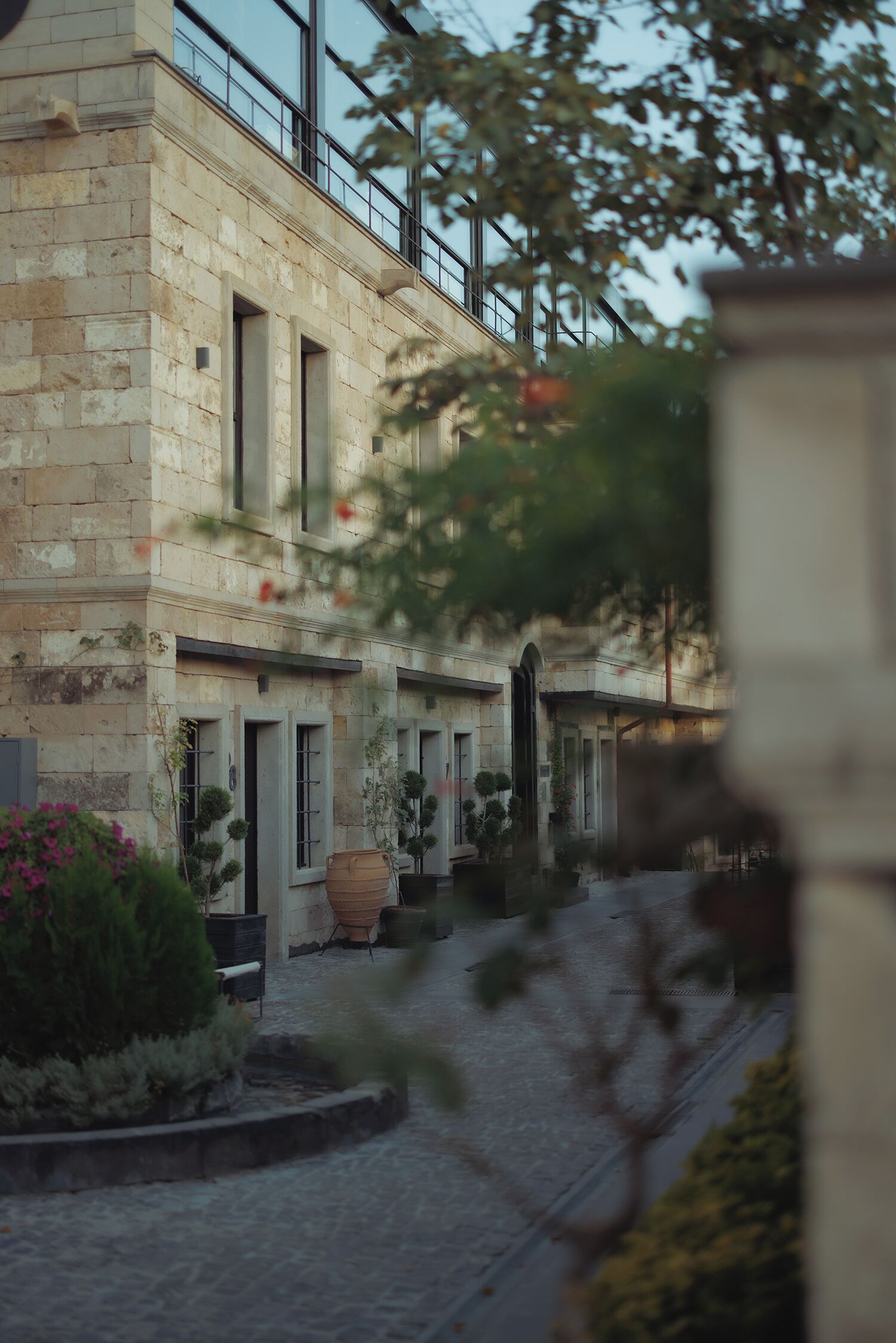 Un edificio de piedra con ventanas de arco y un patio.