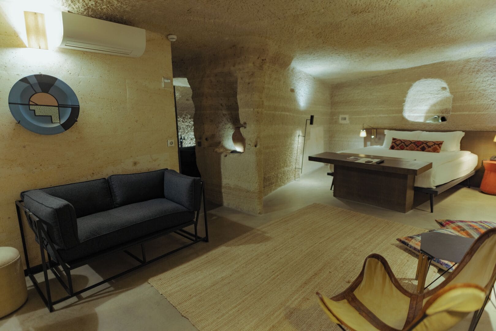 A modern interior with a sofa, a bed, a dining table, and a chair.