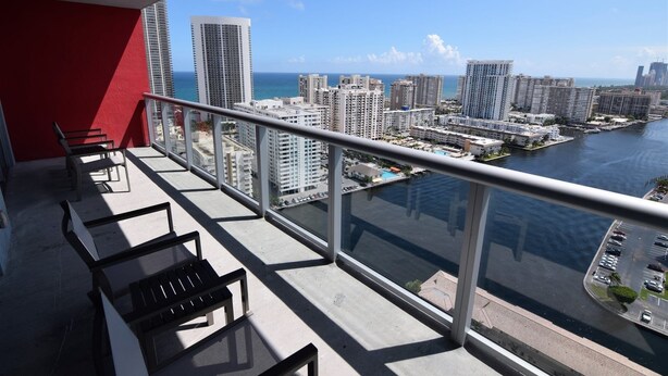 Un balcon donnant sur une marina et des immeubles de grande hauteur.