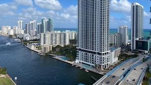 Un hotel moderno de altura, ubicado cerca de un muelle con vistas al océano y a otros edificios.
