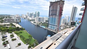 Un edificio alto con una obra en construcción, un río y un puente.