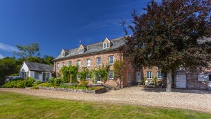 A large stone building with multiple windows and a gravel driveway. - East Harwood Farm Cottage, Timberscombe (Minehead)