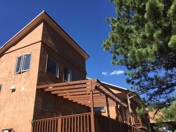 A two-story building with a wooden deck and a star-shaped window.