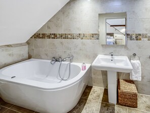 Ein Badezimmer mit Badewanne, Waschbecken und Spiegel.