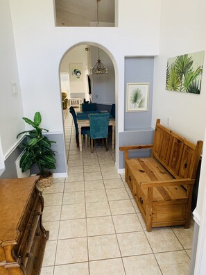 Enjoy a cozy seating area with a wooden bench and table, surrounded by framed artworks and a large potted plant.