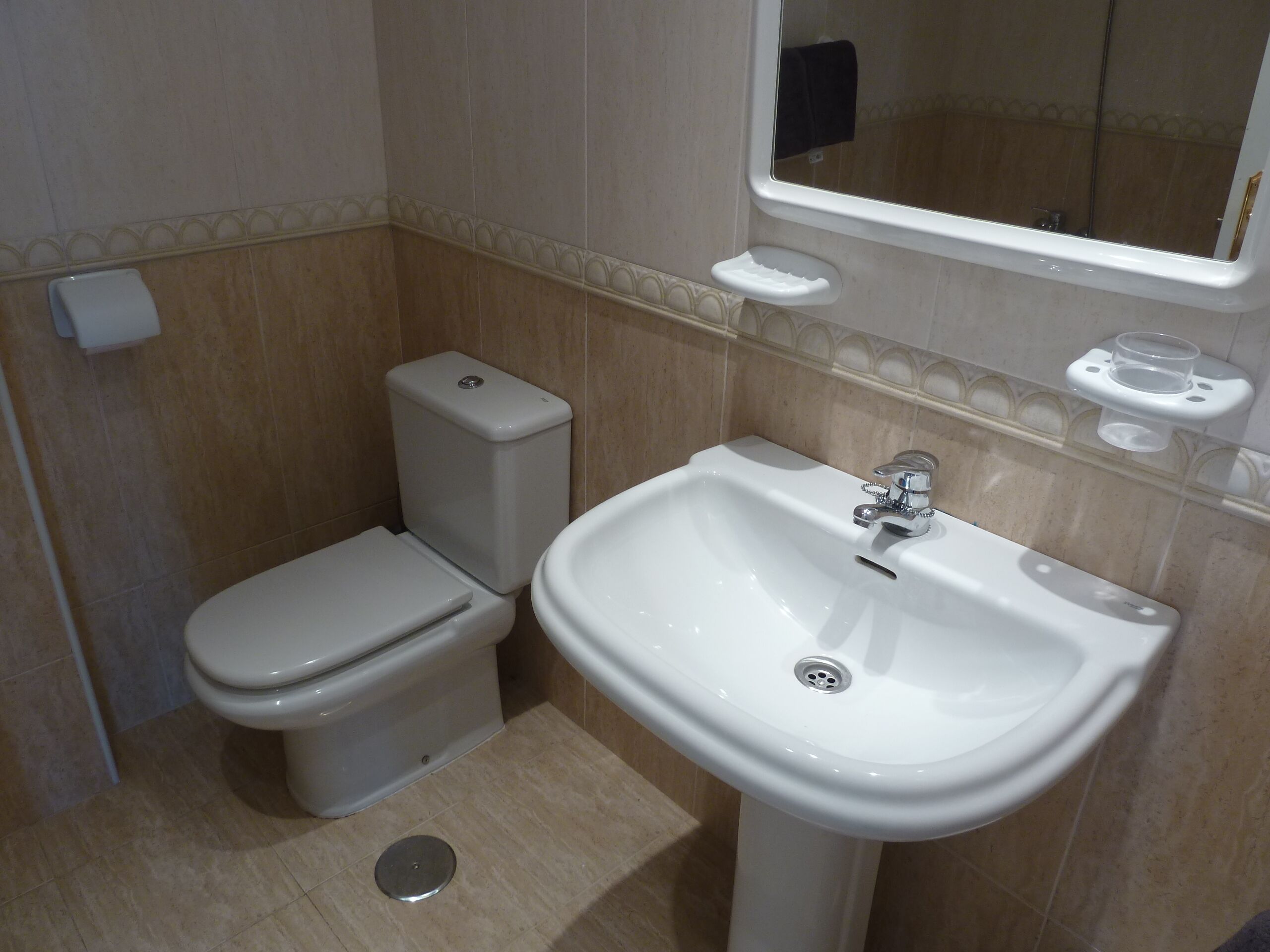 Et lille badeværelse med toilet og vask.