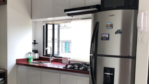 Una cocina moderna con electrodomésticos de acero inoxidable, un ventanal con vistas y un horno empotrado.