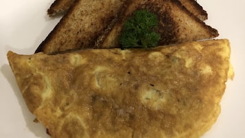 Un plato con una tortilla, pan tostado y una guarnición.