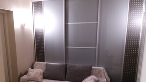 Una sala de estar moderna con un sofá, una mesita redonda y una pequeña mesa auxiliar.
