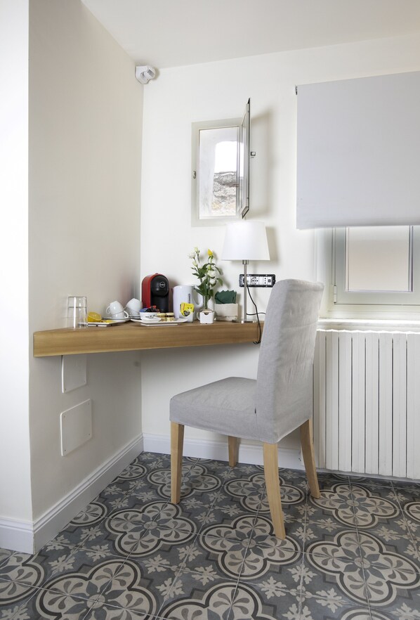 Habitación de esquina con escritorio, silla y radiador.
