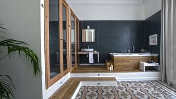 A modern bathroom with a wooden vanity, a sink, and a mirror.