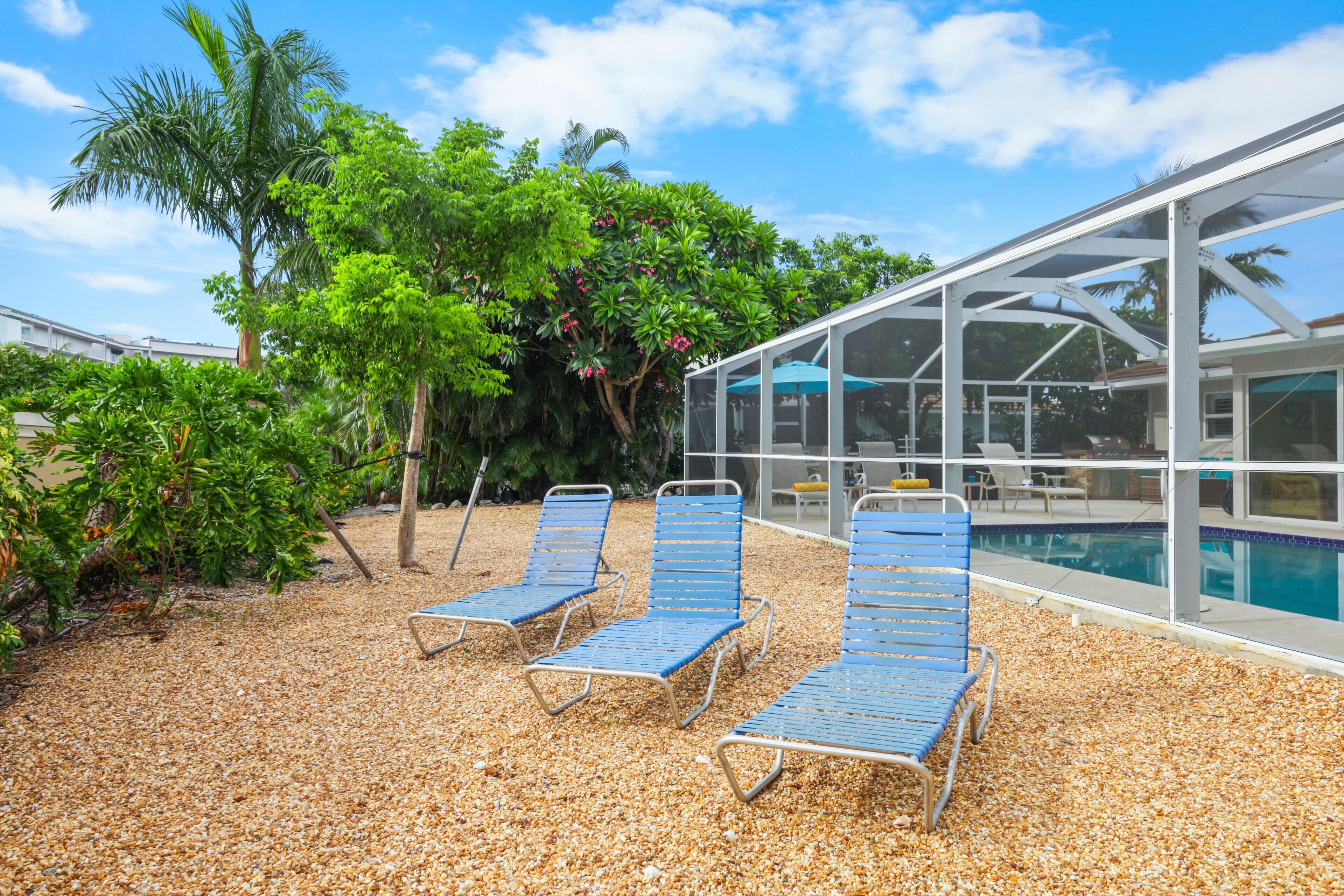 A poolside area with lounge chairs, a covered seating area, and a pool.