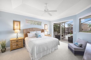 A bedroom with a large bed, a nightstand, a sofa, and a ceiling fan. - Elegantly Decorated Waterfront Home With Pool and spa (Marco Island)