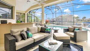 A spacious indoor area with a pool, comfortable seating, and large windows offering a view of the surrounding area.