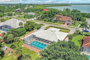 Ett bostadsområde med hus, en swimmingpool och en sjö i bakgrunden.
