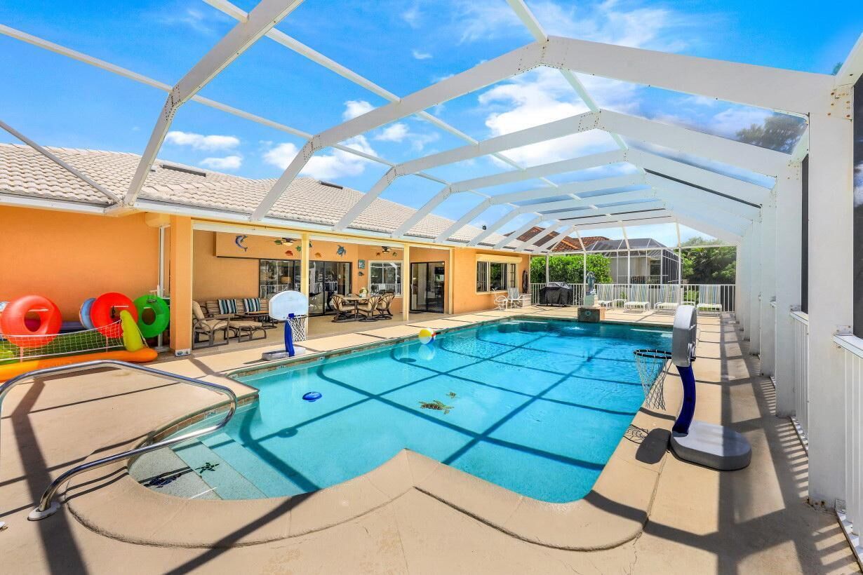 Piscina ao ar livre coberta com espreguiçadeiras e toldo.