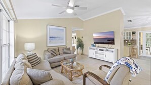 Ein geräumiges Wohnzimmer mit Sofa, Couchtisch und Fernseher.