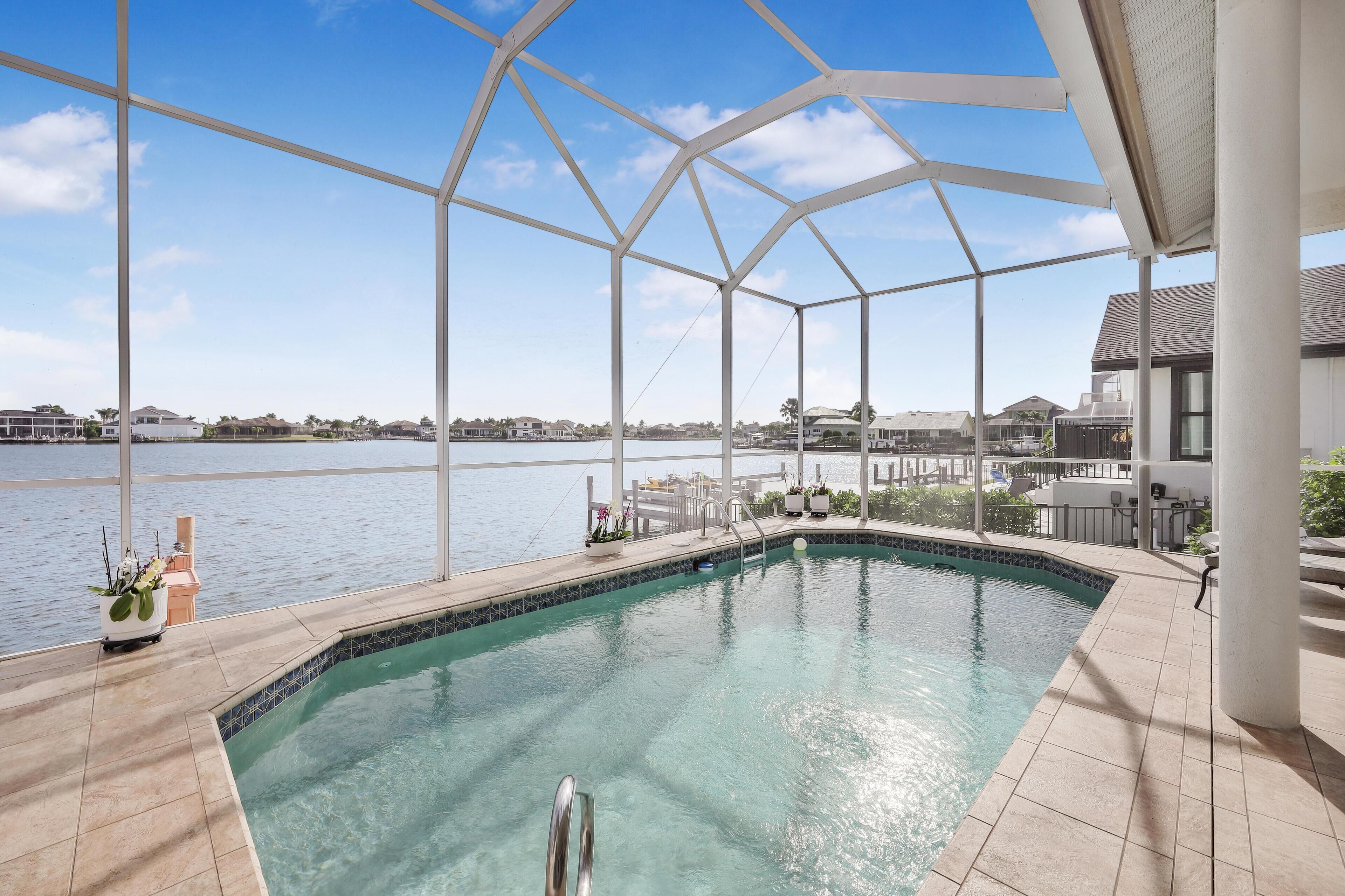 A swimming pool with a clear view of the water and a distant shoreline.