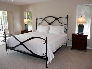 A bedroom with a four-poster bed, two bedside tables, and a window with blinds. - 438 North Barfield Drive (Marco Island)