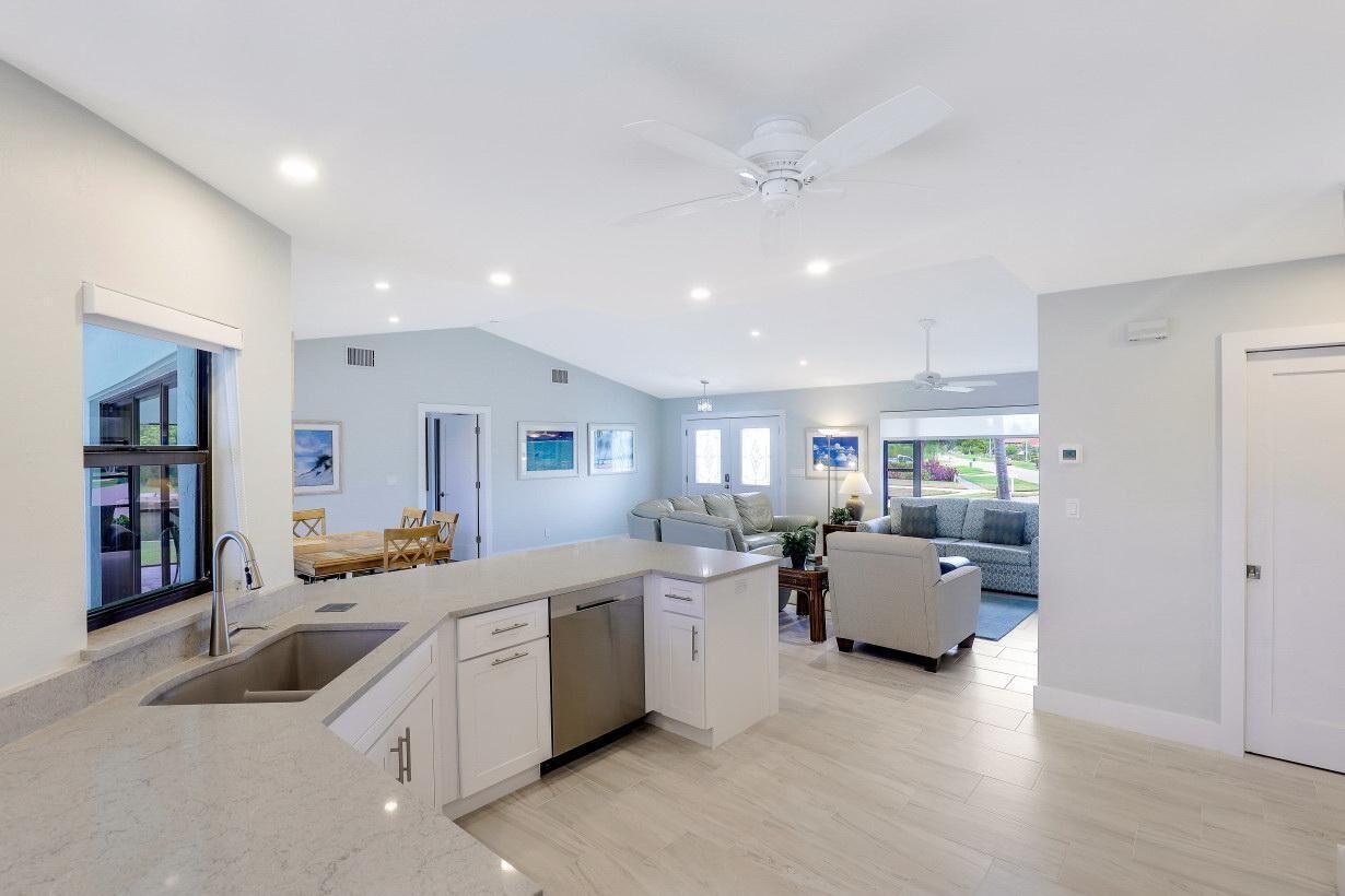 A modern kitchen with a central island, built-in appliances, and a dining area with a view.