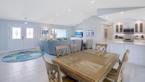 A modern interior with a dining area, kitchen, and living space. - Pet-friendly Waterfront Home on key lot With View (Marco Island)