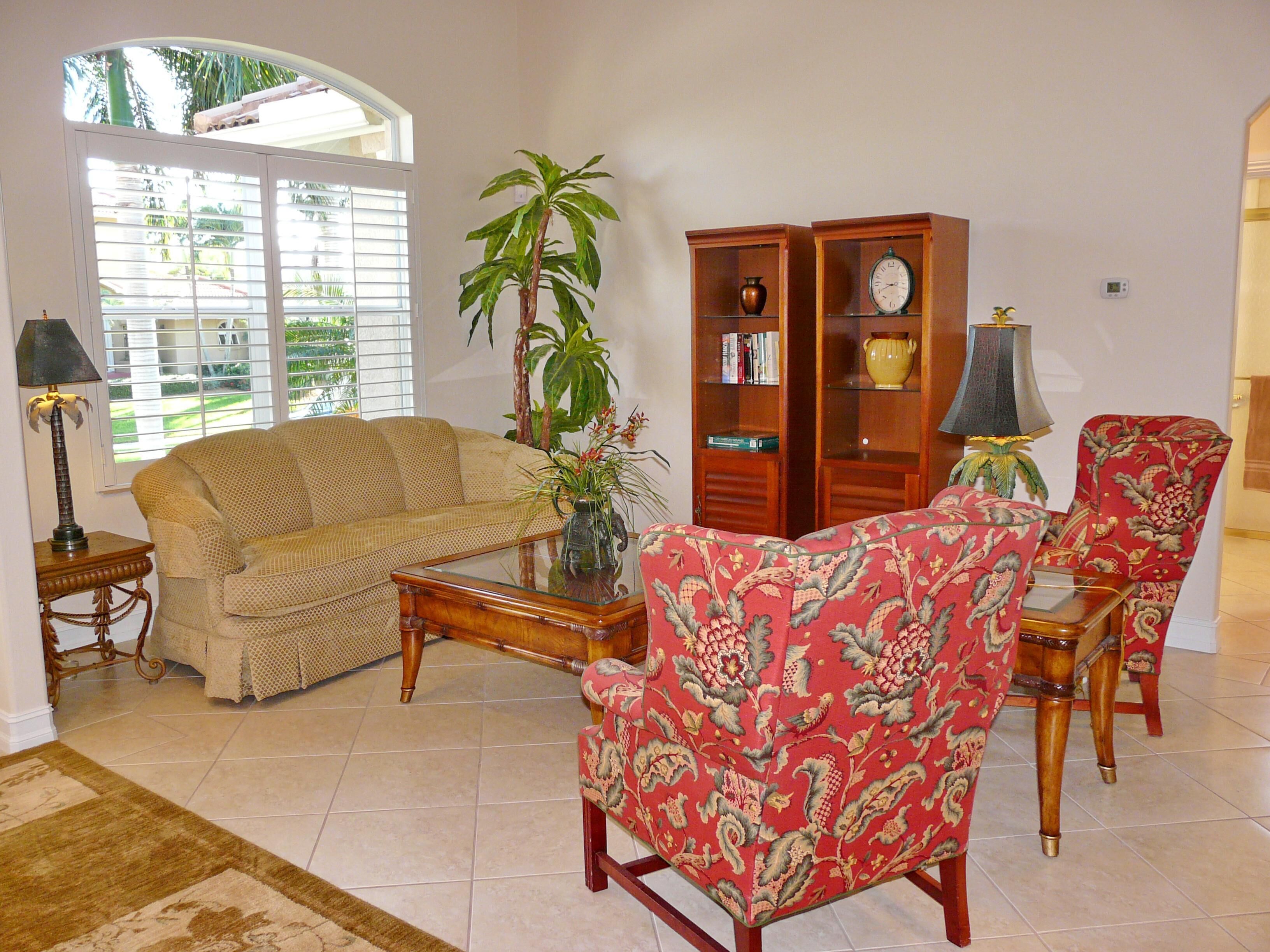 A living room with a sofa, armchair, coffee table, and a bookshelf.