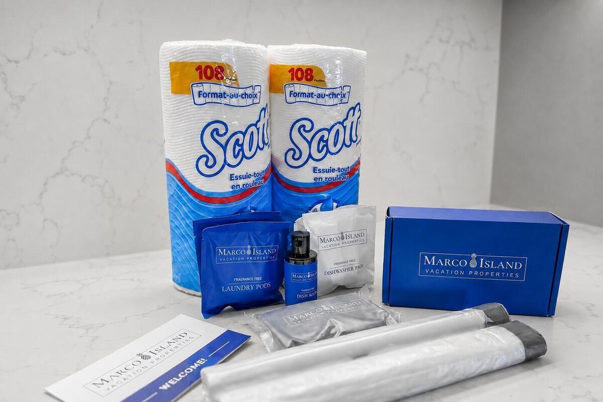 A welcome package from Marco Island Vacation Properties including toilet paper, laundry pods, a dishwashing product, and a welcome card.