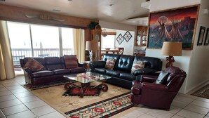 A living room with a sofa, armchair, coffee table, and patterned rug. - Exceptional Lake Powell View Home, lots of parking! (Page)