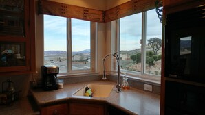 A kitchen with a large window, a coffee maker, and a sink. - Exceptional Lake Powell View Home, lots of parking! (Page)