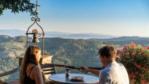 A couple seated at a round table with a view of a mountainous landscape. - Villa with 20 beds divided into 5 apartments (Pari)