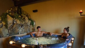A hot tub with a rocky backdrop and candles. - Villa with 20 beds divided into 5 apartments (Pari)