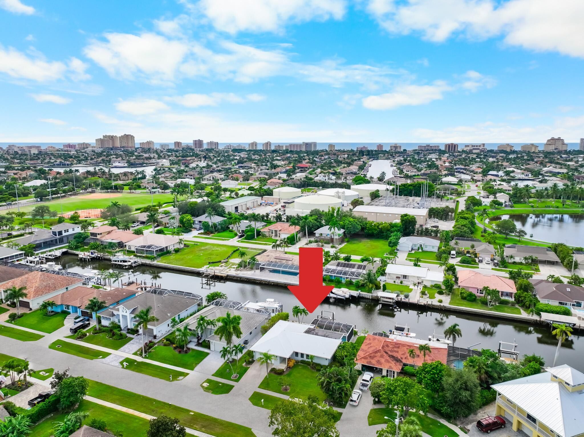An aerial view of a residential area with houses, a marina, and a river.