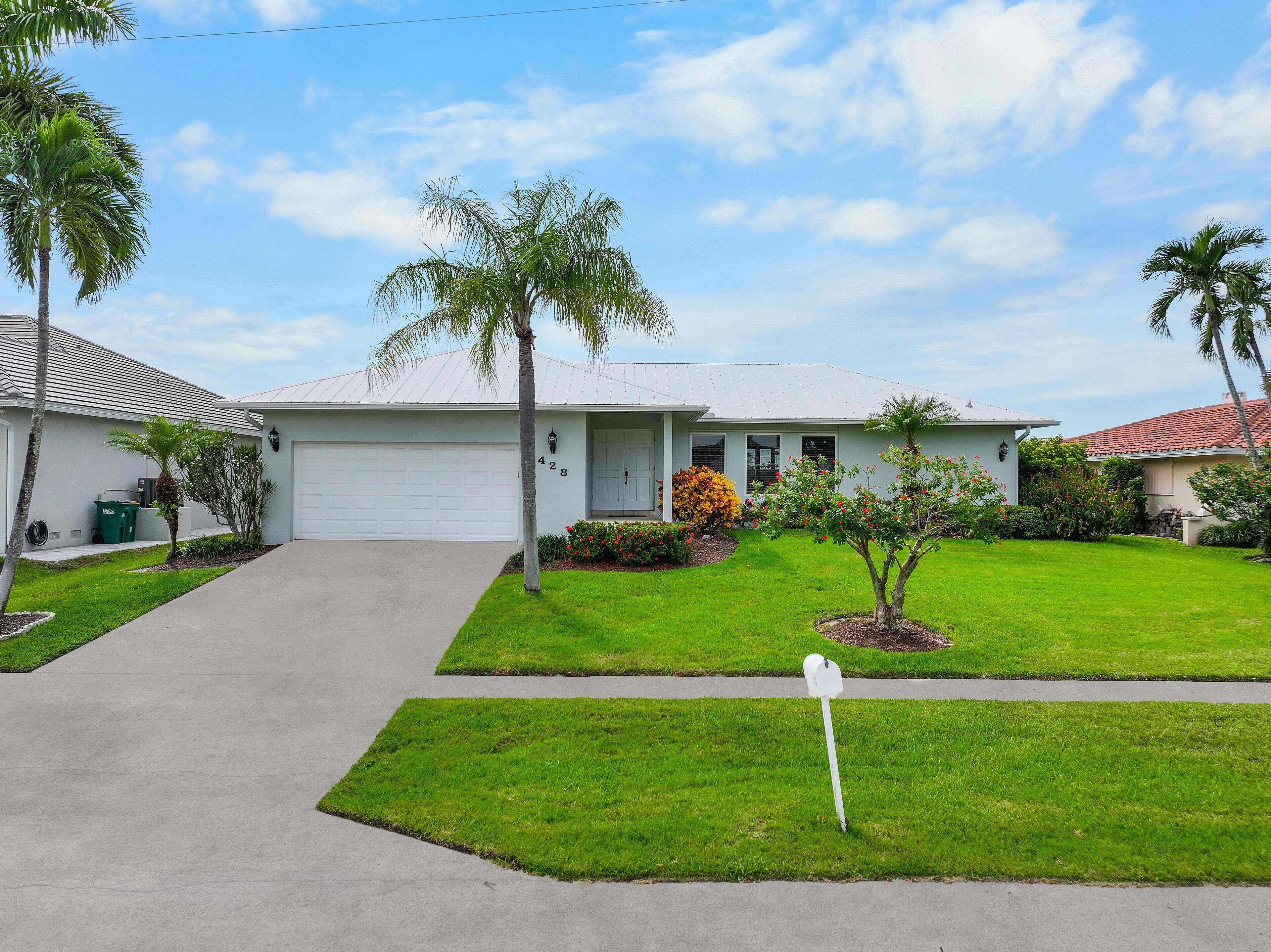 A single-story house with a garage, a well-maintained lawn, and a mailbox.