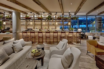 A modern hotel room with a large bed, a sofa, a coffee table, and a TV. at 1 Hotel West Hollywood