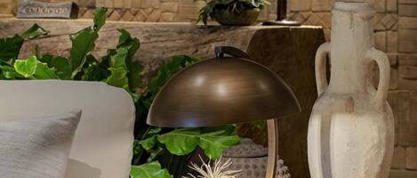 A cozy seating area with a round table, a lamp, a vase, and a book titled "Dry Gardens".